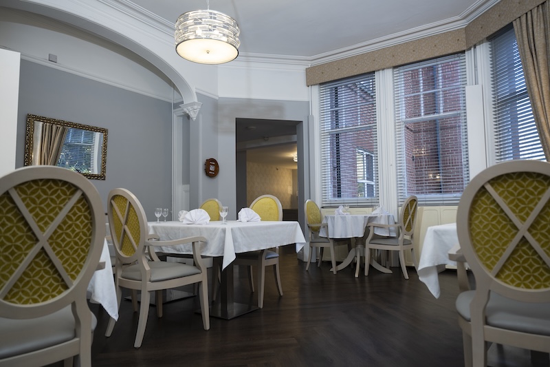dining room with yellow chairs and tables made up